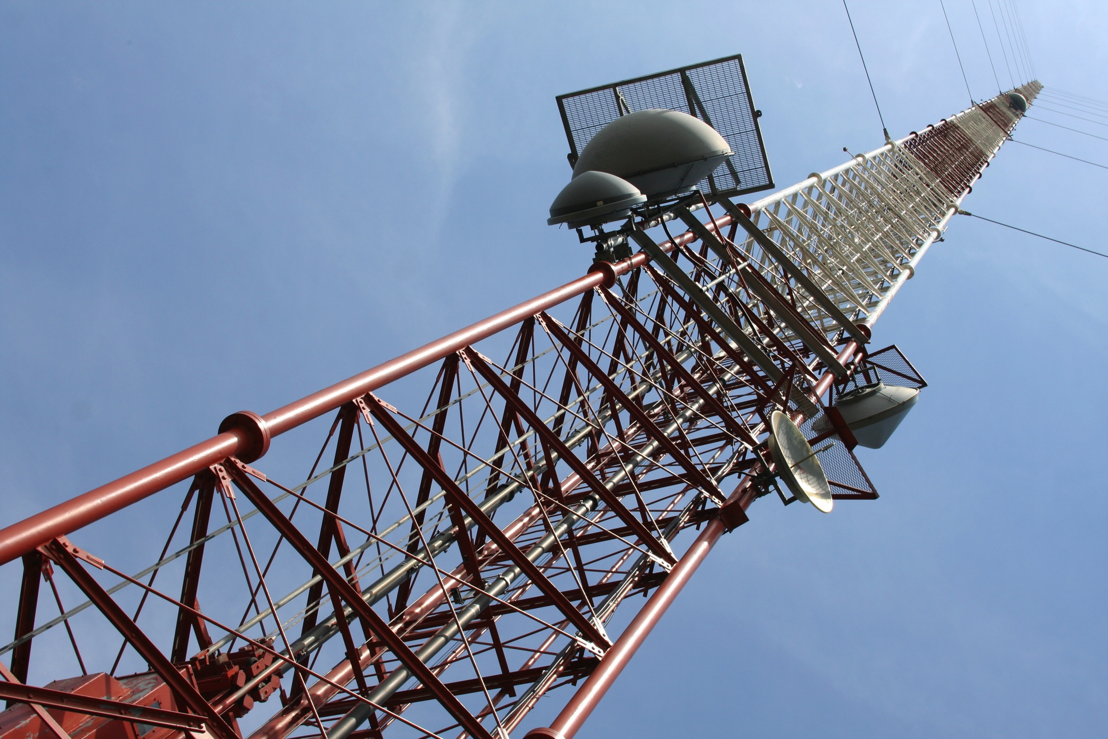 Photo looking up a broadcast transmitter tower at a steep angle from the base